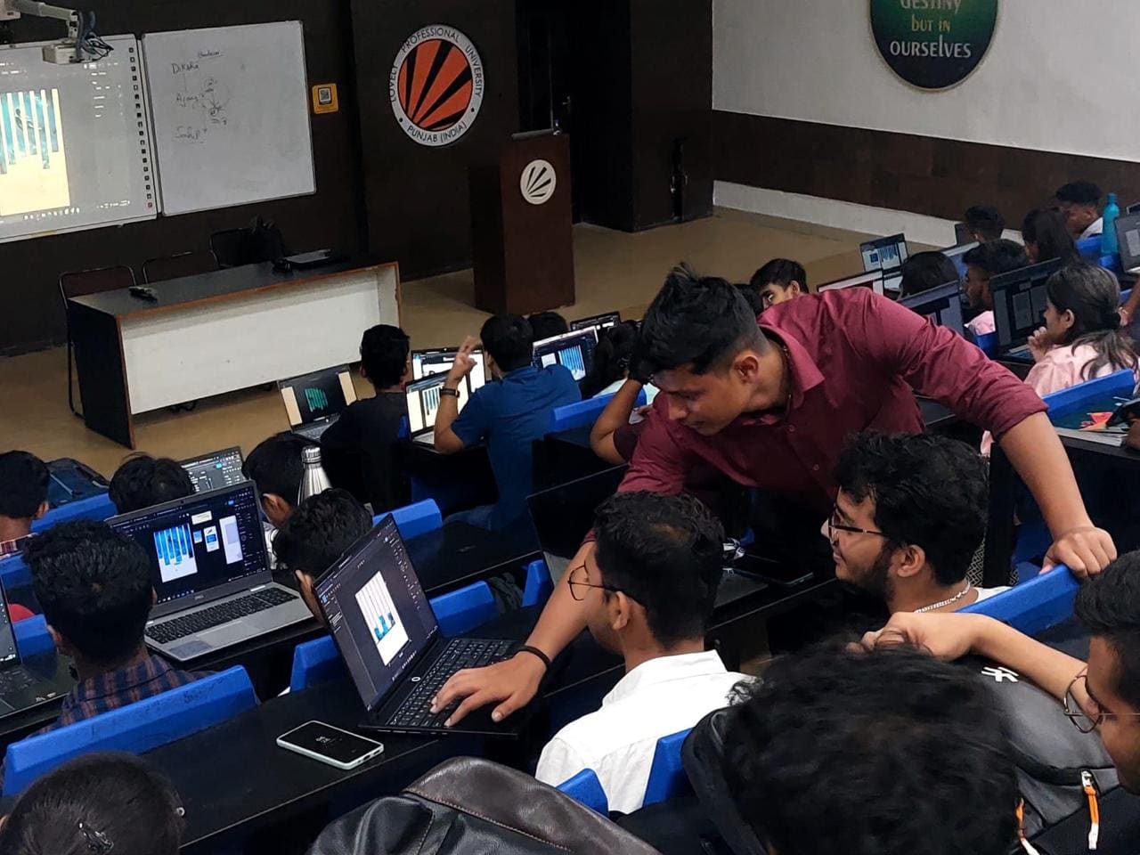 Walking the room during a workshop, helping students at their machines
